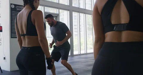 Trainer showing athletes how to preform an exercise Stock Footage 97267879