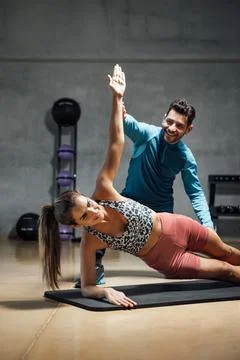 Trainer showing right position to do abs in a gym hiit class. Stock Photos