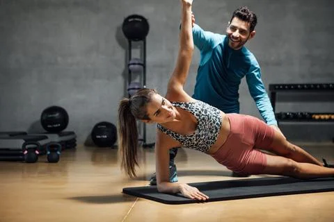 Trainer showing right position to do abs in a gym hiit class. Stock Photos