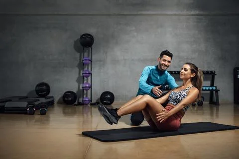 Trainer showing right position to do abs in a gym hiit class. Stock Photos