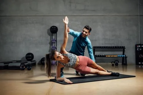 Trainer showing right position to do abs in a gym hiit class. Stock Photos