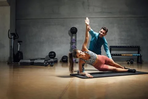 Trainer showing right position to do abs in a gym hiit class. Stock Photos