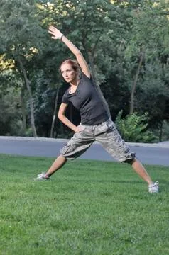 Trainer stretching in forest Stockfoto's