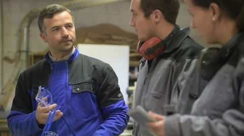 Trainer with students in workshop putting security glasses on Video stock 45662309