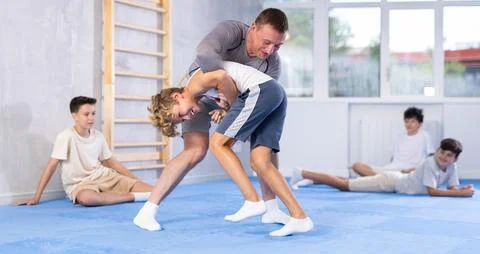 Trainer teaches child methods and positions of ground fighting in judo or Stock Photos