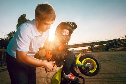 Trainer teaches small bikers to do stunts on a motorcycle Stock Photos