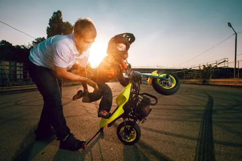 Trainer teaches small bikers to do stunts on a motorcycle Stock Photos