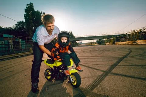 Trainer teaches small bikers to do stunts on a motorcycle Stock Photos