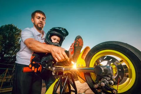 Trainer teaches small bikers to do stunts on a motorcycle Stock Photos