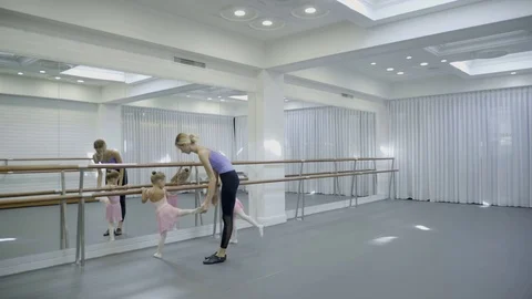 The trainer teaches two girls how to turn around beautifully while ballet class Stock Footage 83295331