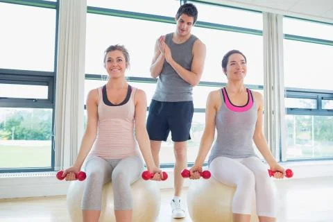 Trainer teaching his class lifting weights Stock Photos