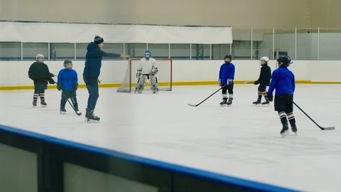 Trainer teaching kid team to play hockey Stock Footage 111342649