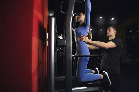 The trainer trains and explains how to do exercises correctly in the gym Stock Photos