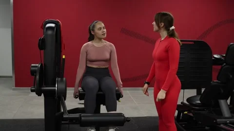 Trainer watches leg extension exercise Stock Footage 337114727