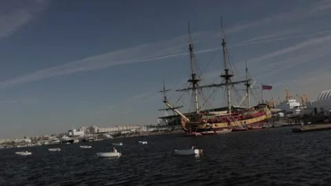 Training boat in the harbor in front of the old frigate Stock Footage 300031429
