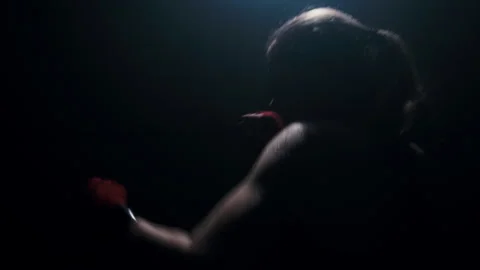 Training boxer silhouetted against a backdrop of light, practicing punches fight Stock-Footage 274449166