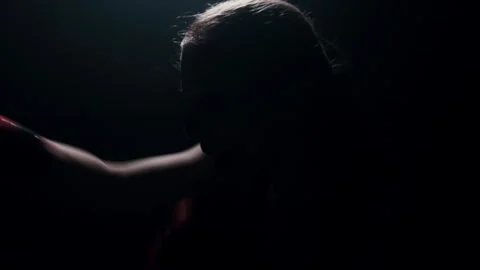 Training boxer silhouetted against a backdrop of light, practicing punches fight Stock Footage 274450419
