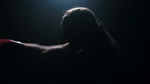 Training boxer silhouetted against a backdrop of light, practicing punches fight Stock-Footage 274450574