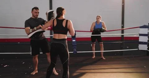 Training centered athlete wearing black sports bra sparring in boxing ring, Stock Photos