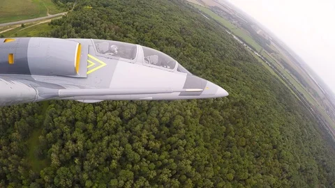 Training gray aircraft fly low over treetops. View from the right wing close up. Stock Footage 118676609