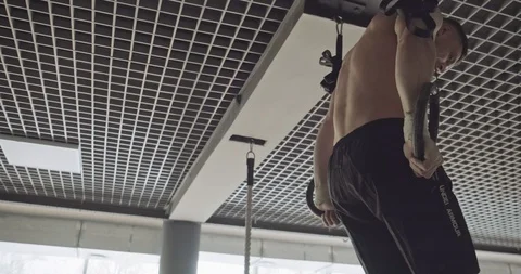 Training with gymnastic rings, strength exercise in closed gym. Men doing Stock-Footage 129981111