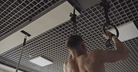 Training with gymnastic rings, strength exercise in closed gym. Men doing Stock-Footage 130014665