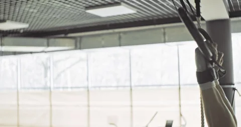 Training with gymnastic rings, strength exercise in closed gym. Men doing Stock Footage 130042404