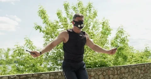 Training with jump rope, intense strength exercise outdoor. Men doing difficult Stock Footage 132854002