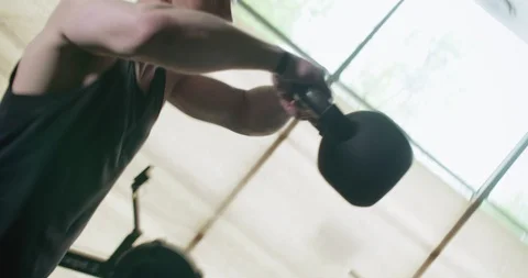 Training with kettlebells, intense strength exercise in closed gym. Men doing Stock-Footage 129978969