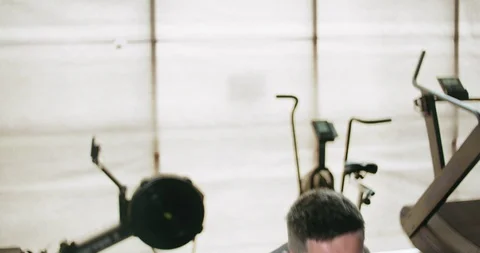 Training with kettlebells, intense strength exercise in closed gym. Men doing Stock Footage 130042335