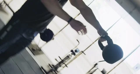 Training with kettlebells, intense strength exercise in closed gym. Men doing Stock Footage 130218941