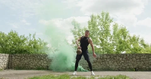 Training with kettlebells, intense strength exercise outdoor with smoke Stock Footage 132776363