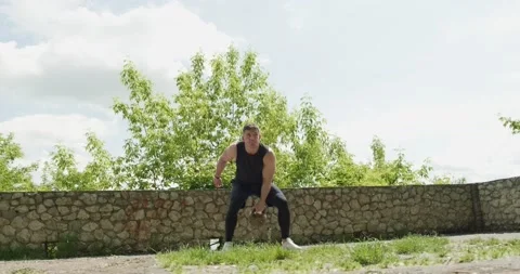 Training with kettlebells, intense strength exercise outdoor. Men doing workout Stock Footage 132776633
