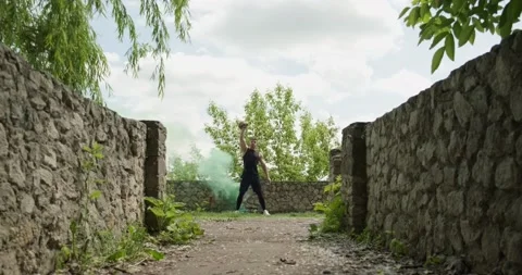 Training with kettlebells, intense strength exercise outdoor with smoke Stock Footage 132973910