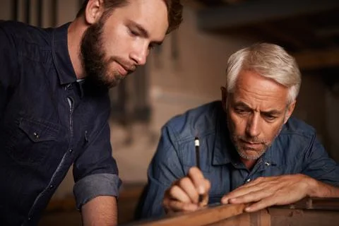 Training, learning and carpenter with apprentice, helping with woodwork in Stock Photos