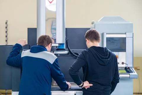 Training new operator on metalworking machine in factory Stock Photos