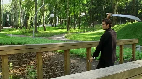 Training in the park. Man practicing elements of tai chi. Slow motion. HD Vídeo Stock 65313854
