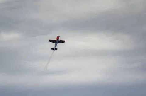 Training plane doing figures in dark skies Stock Photos