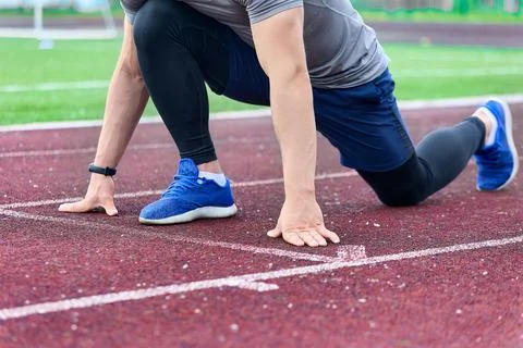 Training process of a sprinter athlete at a stadium with a rubber coating Stock Photos