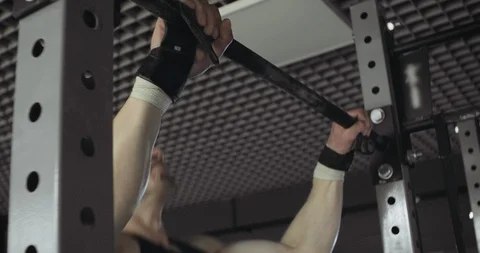 Training pull ups, intense strength exercise in closed gym. Men doing pull ups Stock-Footage 129979833