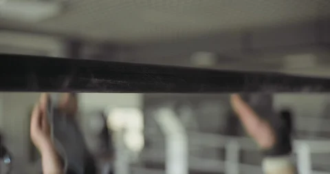 Training pull ups, intense strength exercise in closed gym. Men doing pull ups Stock Footage 129980063