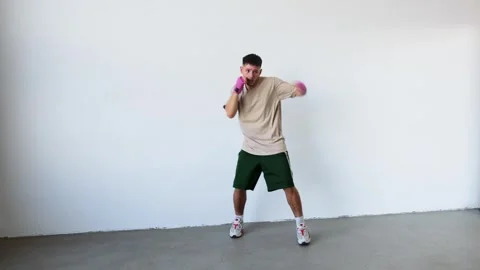 Training session with focus on boxing technique in a minimalist gym space Stock Footage 312383698