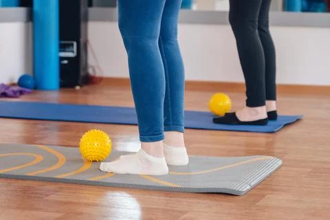 Training session with foot exercises using a fitness ball, focused leg workout. Stock Photos