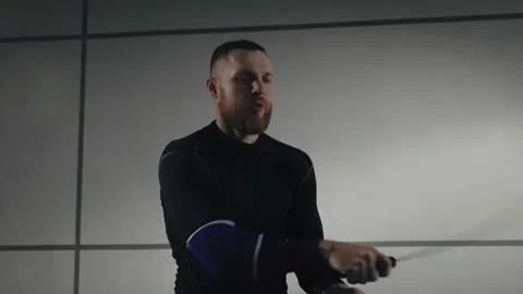 Training with a skipping rope on the background of a gray wall. Slow motion shot Stock Footage 255653226