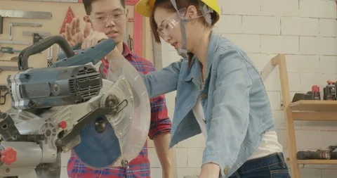 Training woodworker coaching carpentry trainee using cutting machine wood Stock Footage 126443345