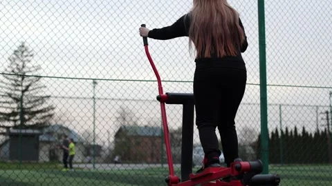 Training in the yard on simulators. The girl is losing weight Stock Footage 270433352