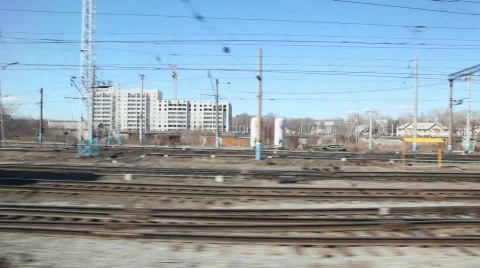 Trains and railroad tracks with city on background from moving train Stock Footage