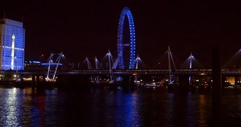 Trains on Bridge over Thames River, London, Night, Ferris Wheel illuminated Stock Footage 122356363