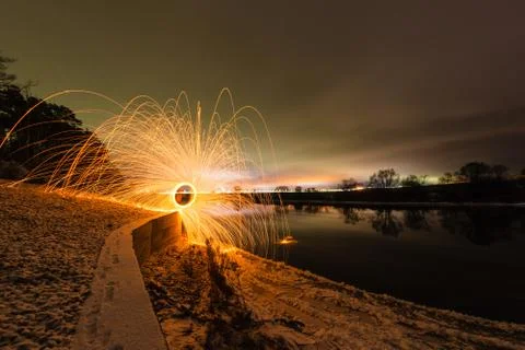 Trajectory of burning sparks reflected on the river surface Stock Photos