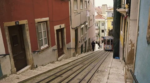 Tram car driving uphill through alley in Lisbon Stock Footage 54628912